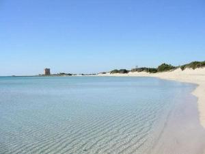 een uitzicht op een strand met zand en water bij Casa Caporosso Giusti in Maruggio