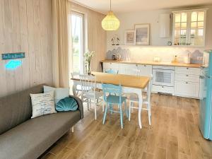 a kitchen and dining room with a table and chairs at Coco Beach Cupel - Domek AQUA in Cupel