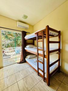 a room with two bunk beds in it with a window at Pousada Recanto das Tartarugas - Nova Direção in Arraial do Cabo