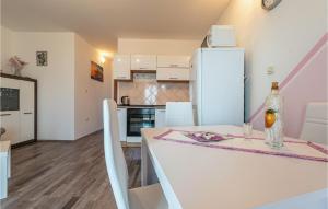 ポヴリャナにある2 Bedroom Cozy Apartment In Povljanaの白いキッチン(テーブル、白い冷蔵庫付)