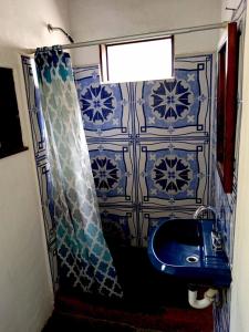 a bathroom with a blue sink and a shower curtain at Cuarto 2 in San Marcos La Laguna