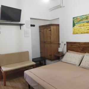 a bedroom with a bed and a tv on the wall at B&B Al Melograno in Sant'Isidoro