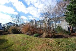 une maison avec des arbres et des buissons dans une cour dans l'établissement Scarborough village 308, à Rehoboth Beach