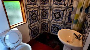 a bathroom with a white toilet and a sink at Cuarto 2 in San Marcos La Laguna