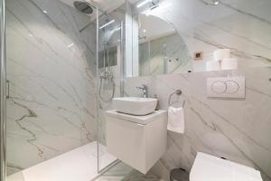 a white bathroom with a toilet and a sink at Good Grace Apartments in Zagreb +45 photos