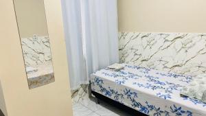 a small bedroom with a bed with blue and white sheets at Kitnet_Familiar 2/4 in Boa Vista