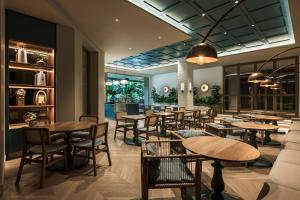 a restaurant with wooden tables and chairs and windows at Hotel Poblado Plaza in Medellín