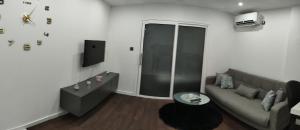 a living room with a couch and a tv at Apartman Ani in Vinkovci