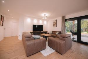 a living room with two couches and a flat screen tv at Villa Verde in Livno