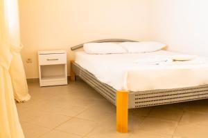 a bedroom with a bed with white sheets and pillows at Vila Kraljica Snežna in Sutomore
