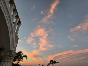a cloudy sky with palm trees and a building at Glenmore Sea View Appartments in Leisure Crest