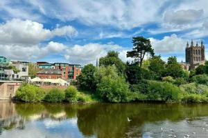 a river with trees and buildings and a city at Beautiful town-flat with character - Bridge street in Hereford
