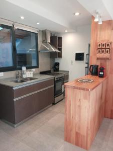 a large kitchen with a sink and a counter at Cabañas Indómita in El Bolsón +12 photos