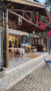 a patio with a table and chairs and a building at Green Flowers Farm in Córrego do Bom Jesus