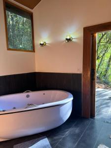 a bath tub in a bathroom with a window at Green Flowers Farm in Córrego do Bom Jesus +70 photos