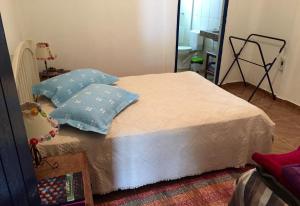 uma cama com duas almofadas num quarto em Casa do Alecrim em São Roque de Minas
