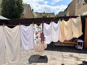 a bunch of shirts hanging on a clothes line at Peaceful 2BR Retreat w Garden Near Oxford in Witney