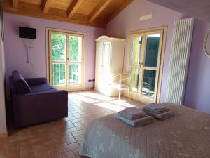 una camera da letto con un letto, una sedia e finestre di Agriturismo La Palazzina di Gorgognano a Pianoro