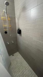 a bathroom with a shower with a tiled floor at Casa Campo Alegre in Bayamon