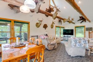 a living room with a table and chairs andanimal heads on the wall at Pet-Friendly Cabin on 86 Acres in Scio Fish, Hike in Wellsville