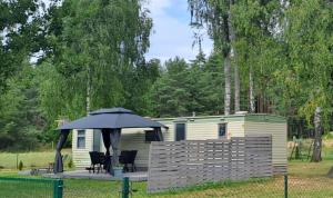 a cabin with an umbrella in front of it at Domek holenderdki ZaCisze 2 in Augustów +17 photos