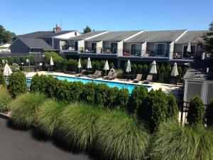 un complexe avec une piscine avec chaises longues et parasols dans l'établissement Scarborough village 308, à Rehoboth Beach