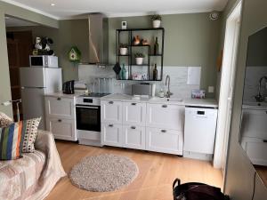 a kitchen with white cabinets and white appliances at Modern Apartments in Tønsberg