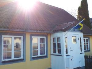 a house with a red roof and a flag on it at Österlens Pärla in Borrby