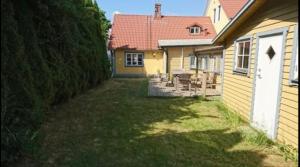 a backyard of a house with a yard with chairs at Österlens Pärla in Borrby