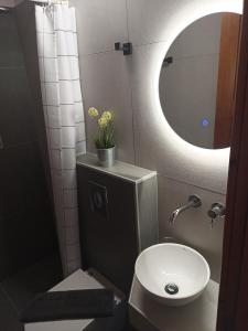 Un baño con inodoro, lavabo y espejo. en Vista Del Mare Luxury Villa, en Koinira
