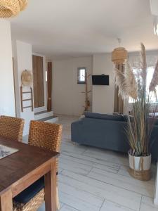 a living room with a blue couch and a table at Entre ciel et bord de mer in Saintes-Maries-de-la-Mer +17 photos