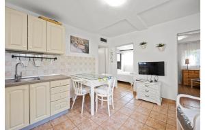 a kitchen with a sink and a table with chairs at 2 Bedroom Nice Home In Brodarica in Brodarica