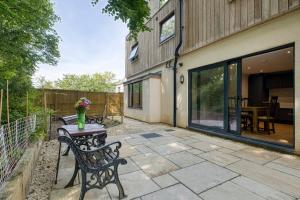 a patio with two benches and a table with flowers on it at H5-4 Bedrooms-2BA-Free Parking-Sleeps 7 in Cole