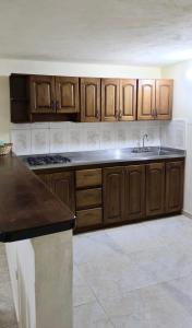 a kitchen with wooden cabinets and a counter top at Casa completa Comodidad-Ubicación Perfecta-CarmenV in Carmen de Viboral +25 photos