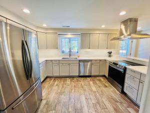 Una cocina con refrigerador de acero inoxidable y pisos de madera. en Central avenue 33476, en Frankford
