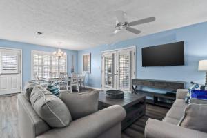 a living room with a couch and a flat screen tv at Contemporary Bungalow / West End PCB / Available NOW! / Perfect for Family in Sunnyside