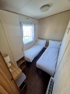 a small room with two beds and a window at Whitstable Trieste - 3 Bedroom, sleeps 8 Pet friendly, family friendly in Seasalter