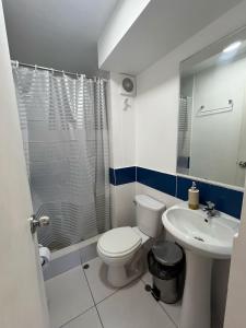 a white bathroom with a toilet and a sink at Hermoso departamento totalmente amoblado - Lte San Miguel in Lima