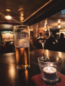 a glass of beer and a candle on a table at Whitstable Trieste - 3 Bedroom, sleeps 8 Pet friendly, family friendly in Seasalter