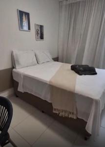 a bedroom with a bed with white sheets and a bag on it at Muro Alto Comfort - Family Flat - 2 quartos in Ipojuca +28 photos