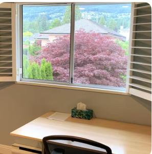 una ventana con una mesa y una silla delante de ella en Private Room with Mountain view, en West Vancouver