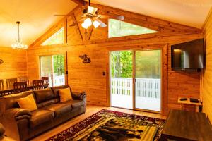 a living room with a leather couch and a tv at Deer Crest Cabin 5Bedroom near JFBB ski area/Lake in Towamensing Trails