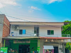 a building with a green and white at Hostal berpé in Coveñas +3 photos