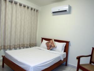 a bedroom with a bed and a window with a air conditioner at Apeksha Sunset in Addalachenai