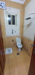 a bathroom with a toilet and a window at اجنحة الشام بلس in Al Madinah +1 photo