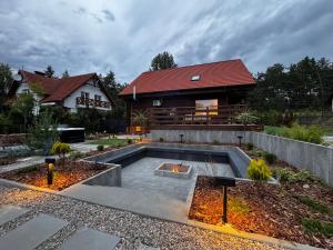 a house with a fire pit in the yard at Checz Swornegacie - Dom wakacyjny nad jeziorem Karsińskim in Swornegacie 