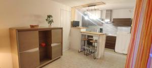 una cucina con un bancone e un tavolo di Appartement terrasse dans une résidence calme a Cap d'Agde