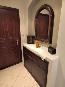 La salle de bains est pourvue d'une armoire en bois et d'un miroir. dans l'établissement Fridas Home Apartment, à Alexandroúpolis