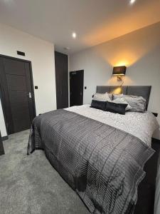 ein Schlafzimmer mit einem großen Bett mit einer Lampe in der Unterkunft Modern 3bed | 3en-suite | Garden in Reading