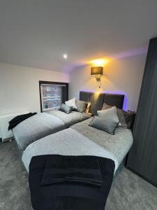 2 Betten in einem Zimmer mit lila Beleuchtung in der Unterkunft Modern 3bed | 3en-suite | Garden in Reading